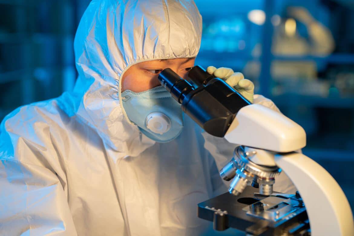 Virologe untersucht Virus unter dem Mikroskop im Labor.